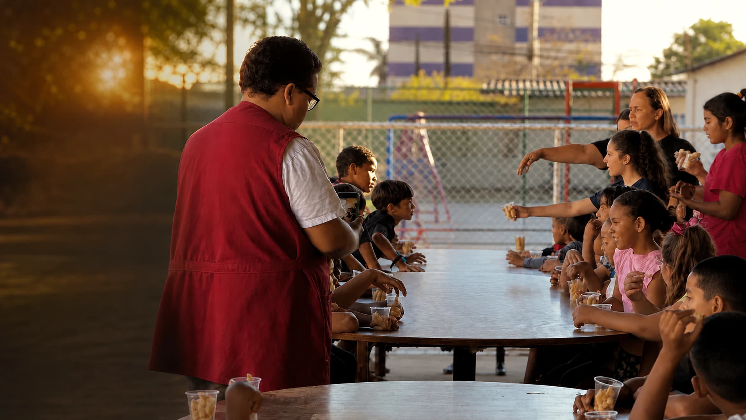 Voluntário servindo lanche para as crianças do CEPAI
