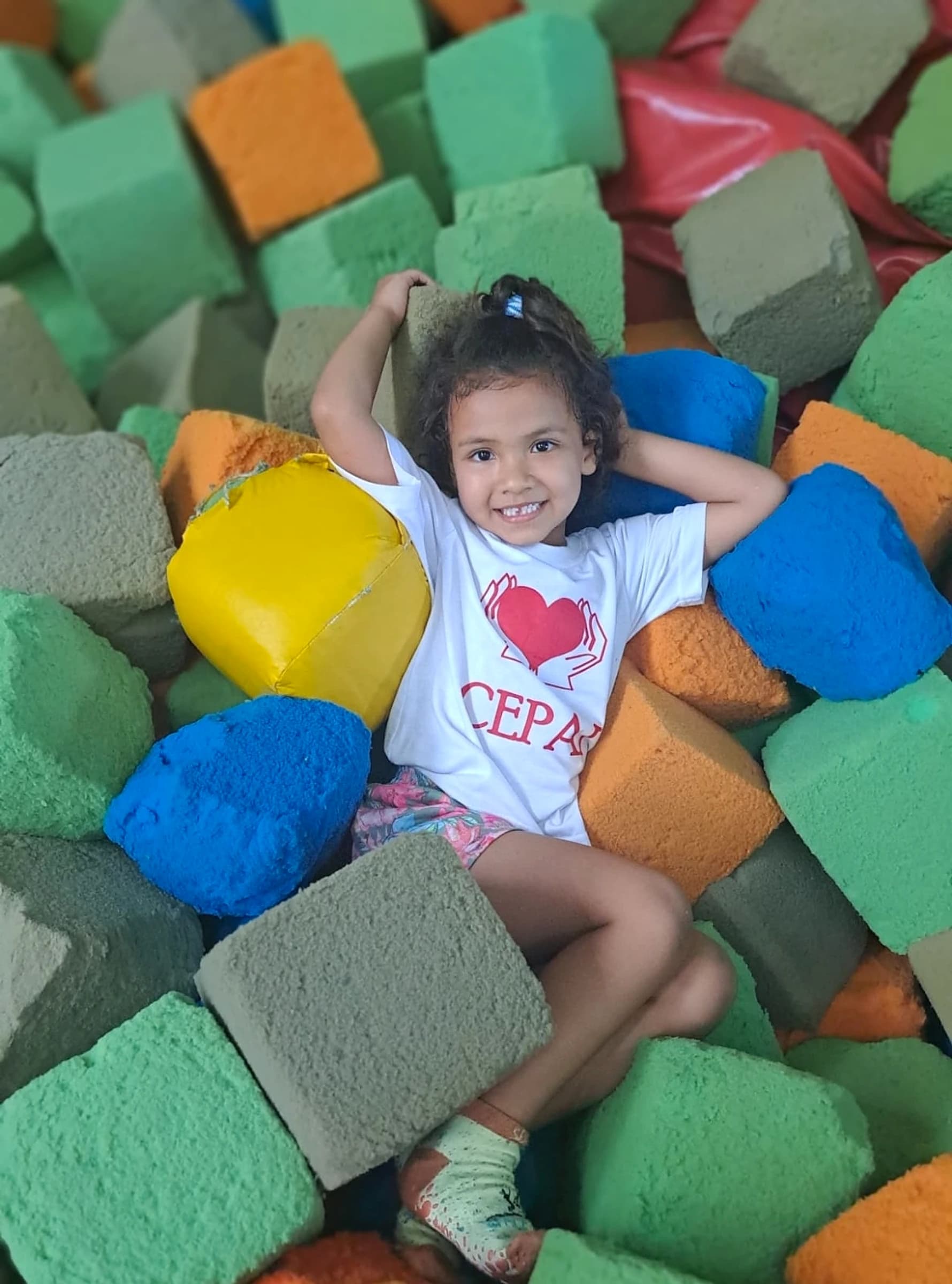 Criança atendida pelo CEPAI sorrindo em uma atividade recreativa